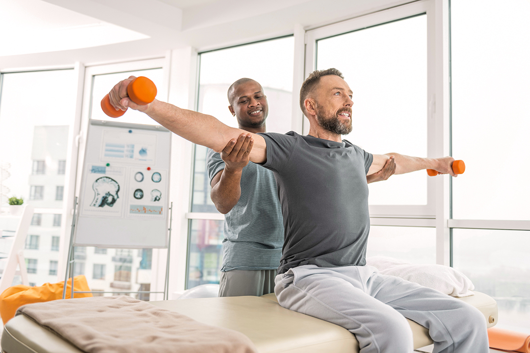 man holding weights in a physical therapy office