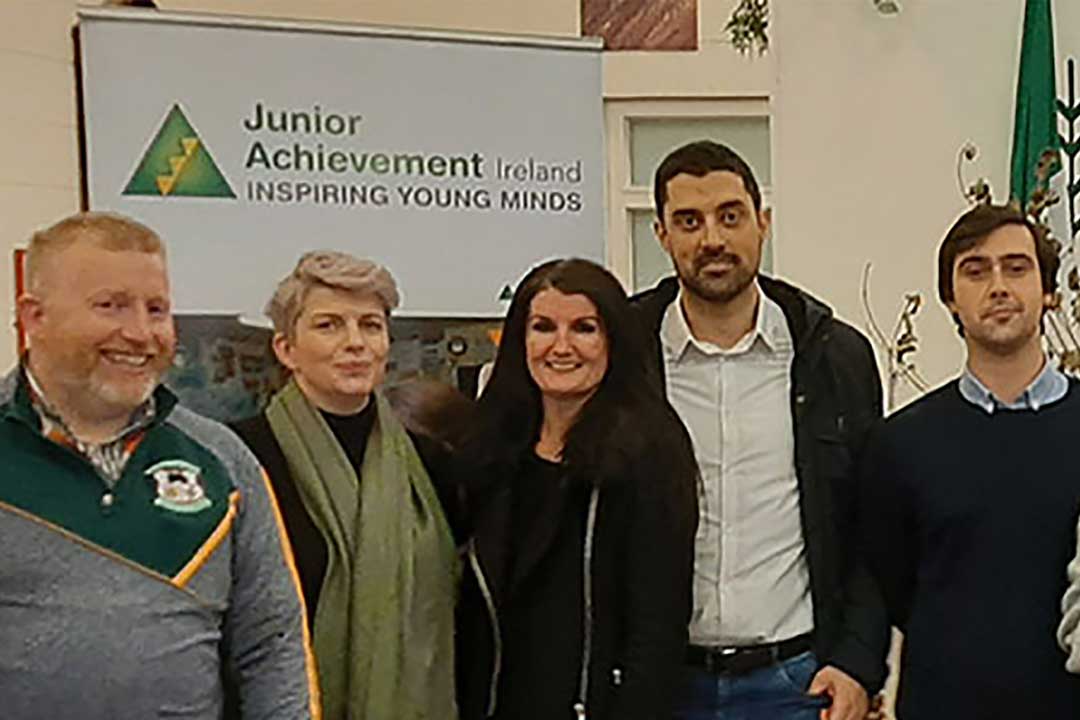 Optum colleagues in front of a Junior Achievement Ireland banner