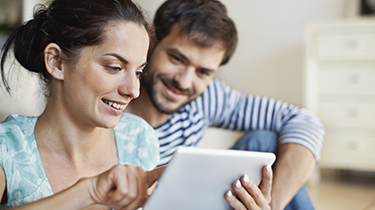 Man and woman looking at a mobile device together and smiling 